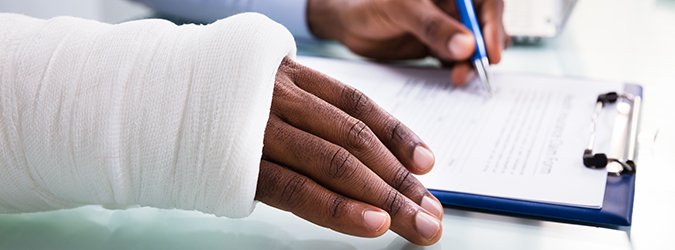 Injured Man Filling Insurance Claim Form